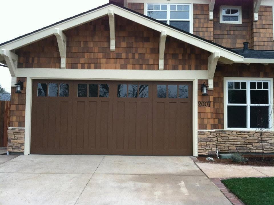 A Cape Cod Craftsman style house with a garage door